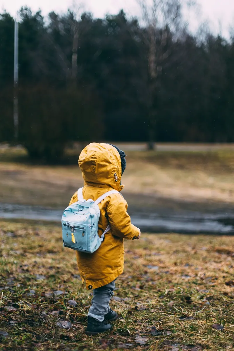Jeune enfant marchant dehors, vu de dos